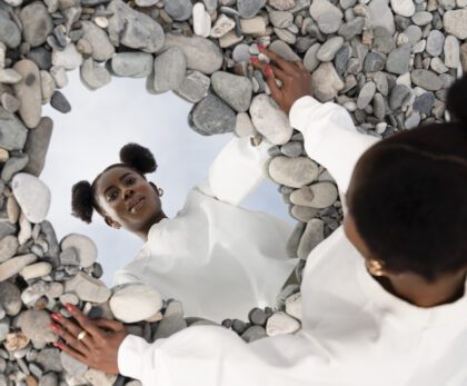 jeune-femme-vetue-de-blanc-posant-avec-miroir-dans-les-rochers